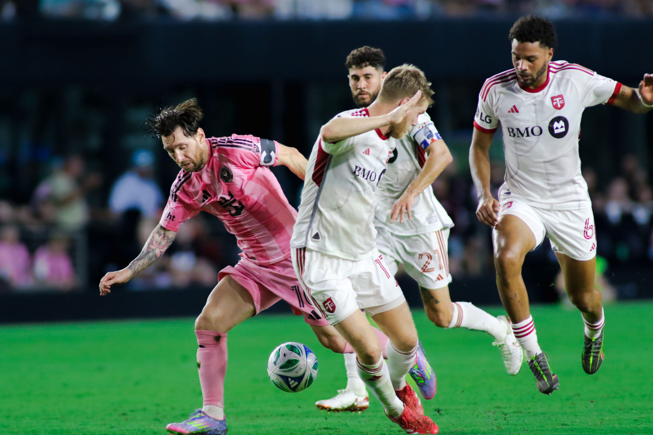 Lionel Messi finds himself tightly marked by three Toronto FC players — midfielder Kosi Thompson, captain Jonathan Osorio, and 17-year-old Sigurd Rosted — as they combine to contain the Inter Miami playmaker in a tense moment of the match.